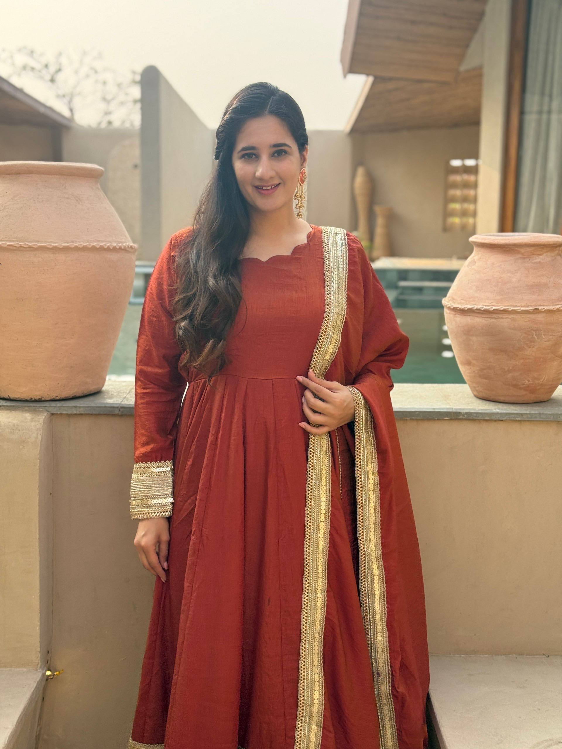 Regal Rust Orange Flared Anarkali Suit Set Featuring Ornate Gold Sequined Borders, a Scalloped Neckline, and an Elegant Tie-Up Back